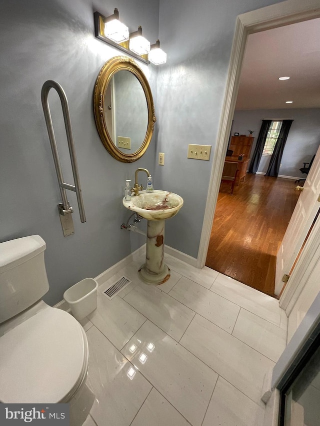 bathroom with hardwood / wood-style floors and toilet