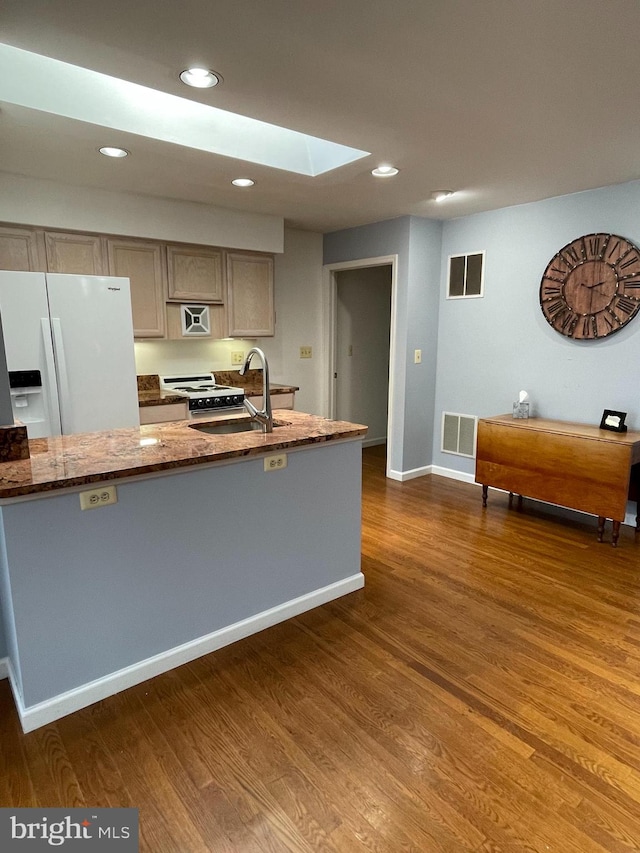 kitchen with dark hardwood / wood-style floors, sink, white fridge with ice dispenser, and a skylight