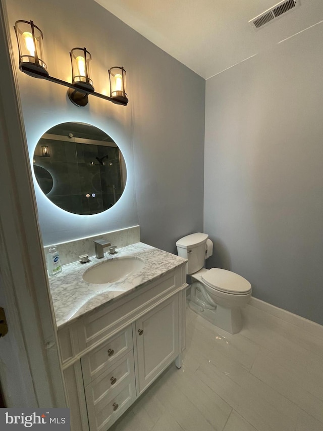 bathroom featuring tile patterned flooring, toilet, and vanity