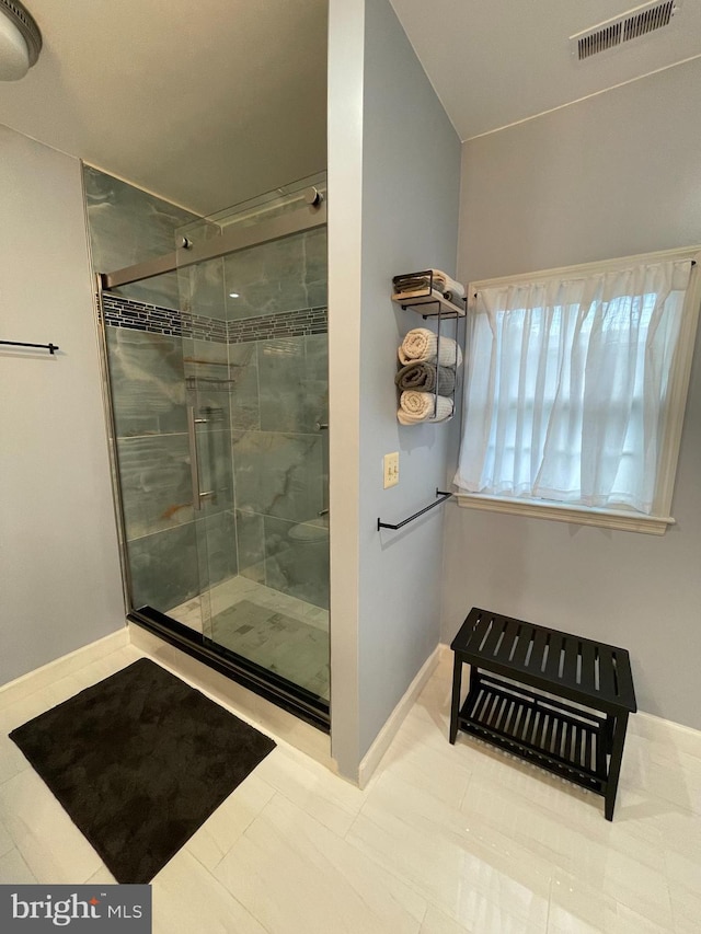 bathroom featuring a shower with door and tile patterned floors