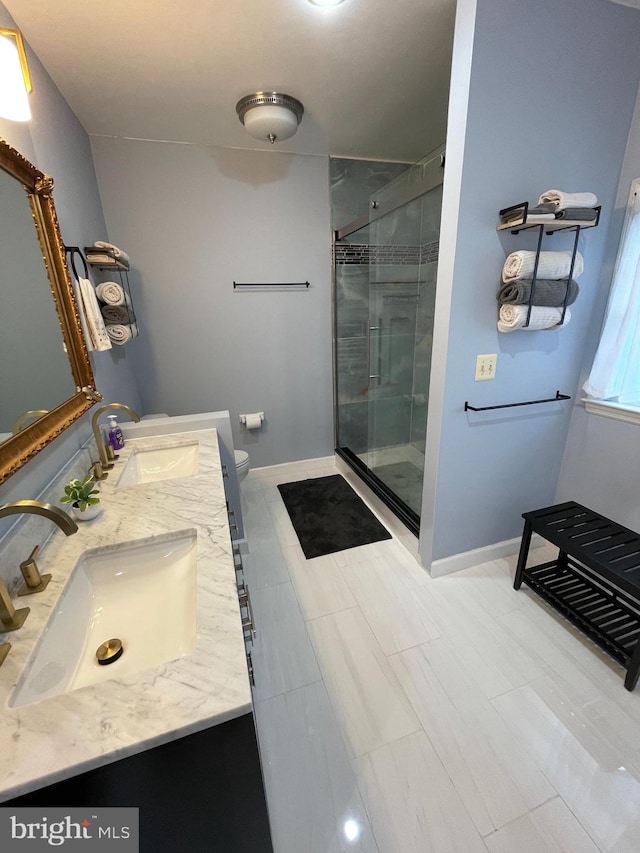 bathroom with tile patterned floors, toilet, a shower with door, and vanity