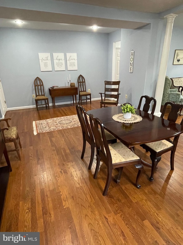 dining room featuring hardwood / wood-style floors and decorative columns