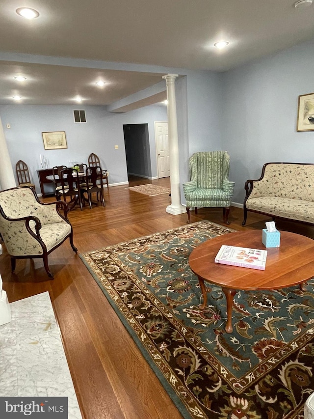 living room featuring hardwood / wood-style floors and decorative columns