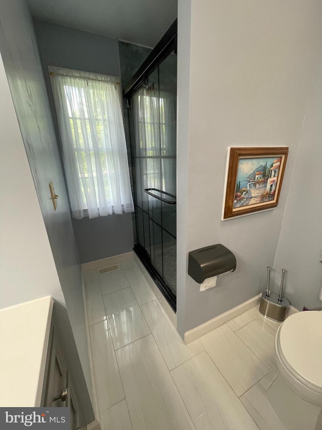 bathroom with toilet, vanity, and tile patterned floors