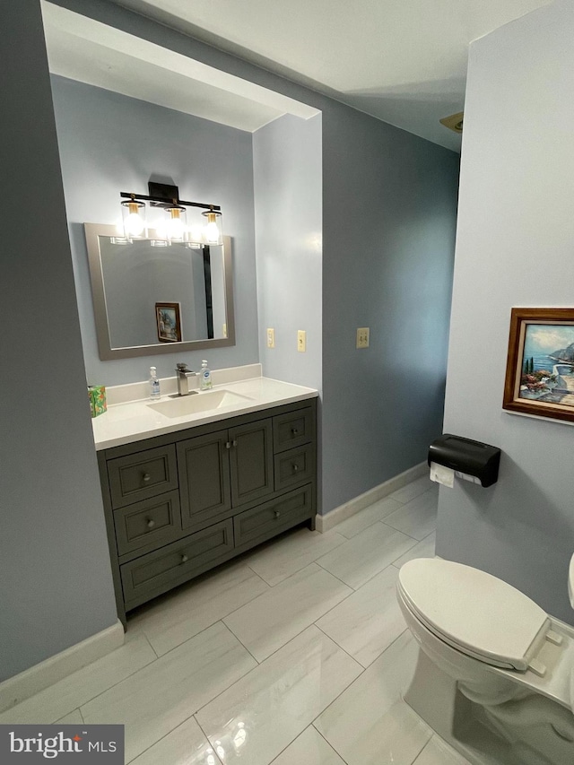 bathroom featuring tile patterned flooring, toilet, and vanity