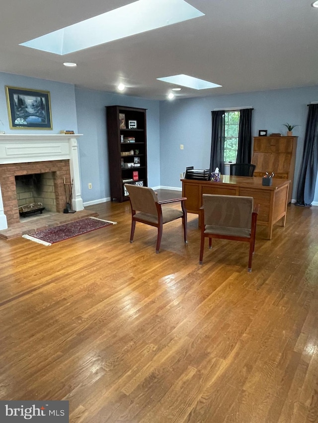 interior space with wood-type flooring, a skylight, and built in shelves