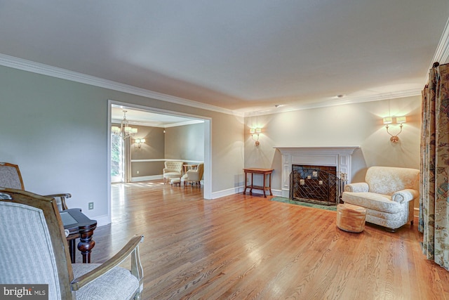 living area featuring a fireplace with flush hearth, crown molding, baseboards, and wood finished floors