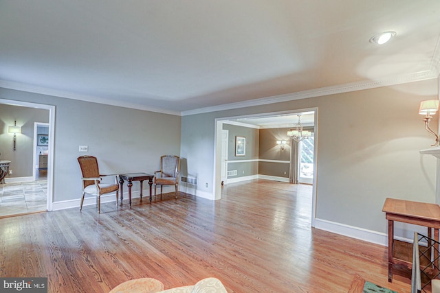 living area featuring light wood-type flooring, baseboards, and ornamental molding