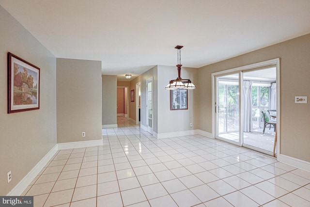 empty room with light tile patterned floors and baseboards