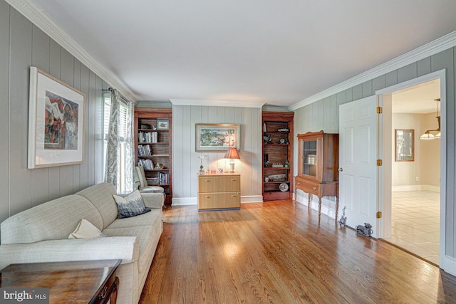 living room with crown molding, baseboards, and wood finished floors