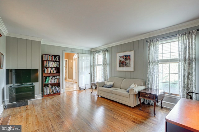 living area featuring ornamental molding, plenty of natural light, and wood finished floors