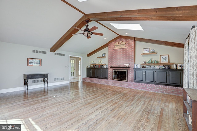 unfurnished living room featuring light wood-style floors, a brick fireplace, and visible vents