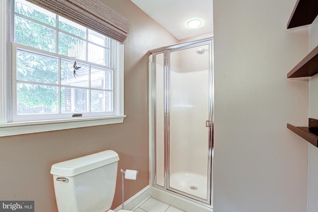 bathroom featuring baseboards, a stall shower, toilet, and tile patterned floors