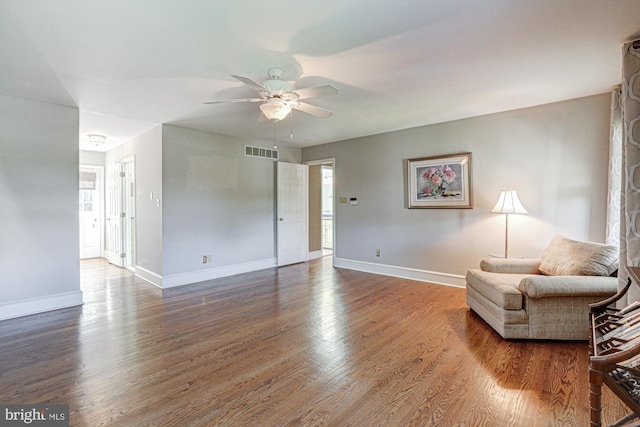 sitting room featuring a ceiling fan, visible vents, baseboards, and wood finished floors