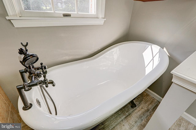 details featuring a freestanding tub and baseboards