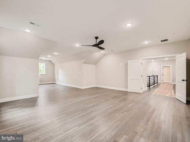 bonus room featuring visible vents, baseboards, ceiling fan, light wood-style flooring, and vaulted ceiling