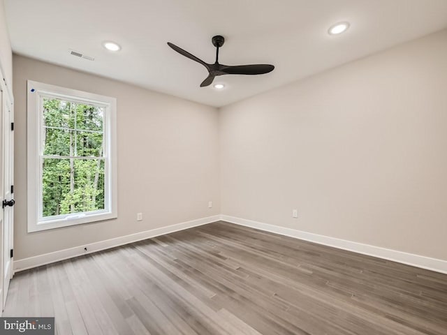 empty room with recessed lighting, wood finished floors, and baseboards