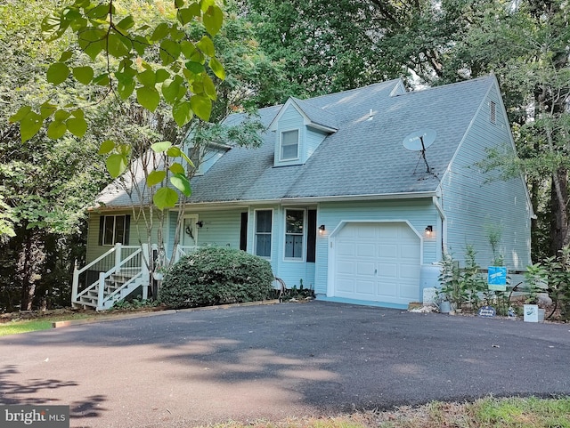 cape cod-style house with covered porch and a garage