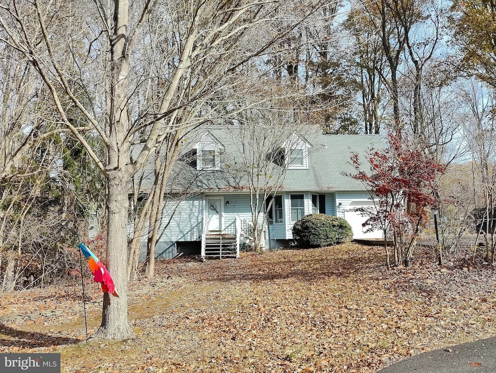 cape cod home featuring a garage