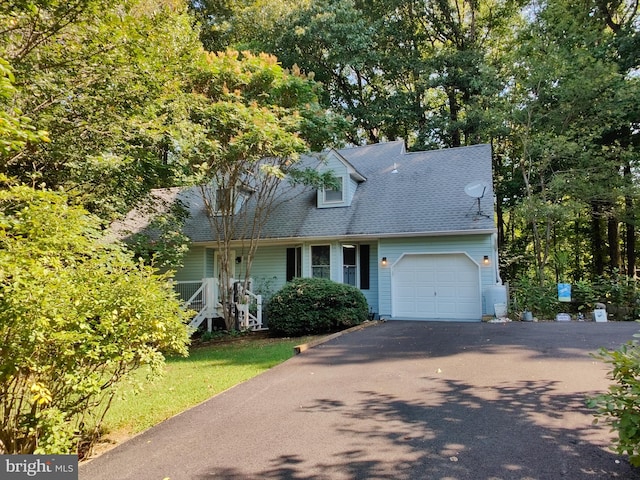 cape cod home featuring a garage