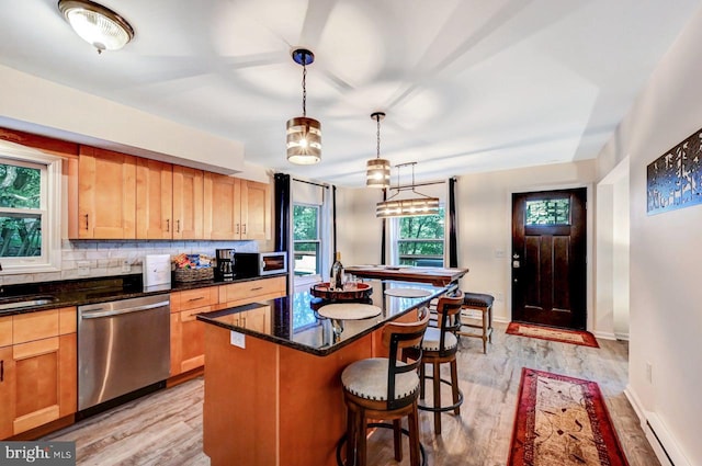 kitchen with dishwasher, a center island, light hardwood / wood-style floors, and a healthy amount of sunlight