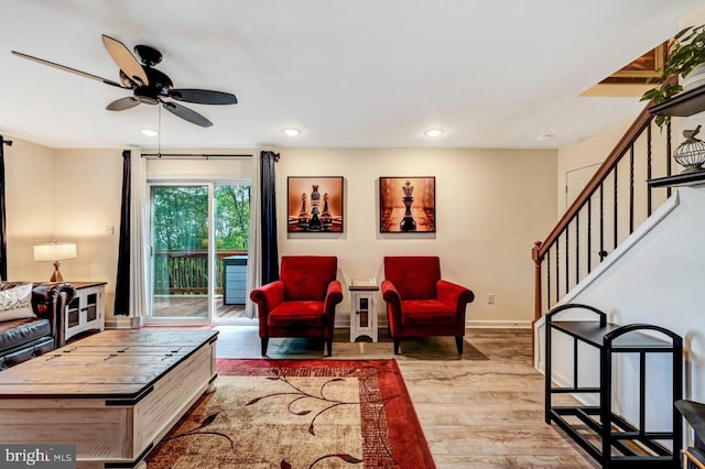 living room with ceiling fan and light hardwood / wood-style flooring