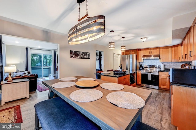 dining space featuring an inviting chandelier and light hardwood / wood-style flooring