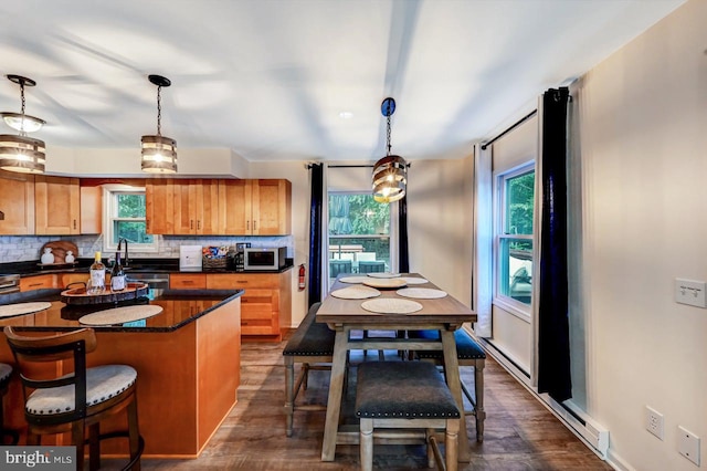 kitchen featuring pendant lighting, a breakfast bar, dark hardwood / wood-style flooring, and backsplash