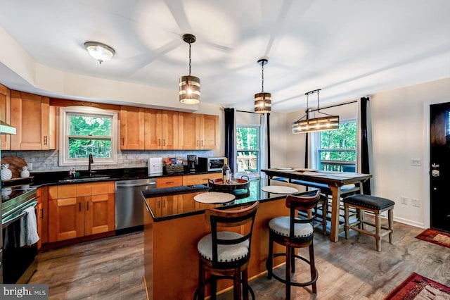 kitchen featuring a wealth of natural light, a center island, stainless steel appliances, and sink