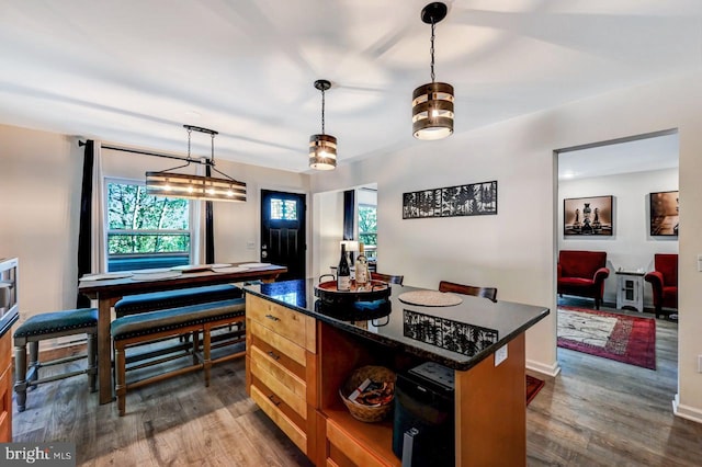 kitchen featuring a center island, dark wood-type flooring, and hanging light fixtures