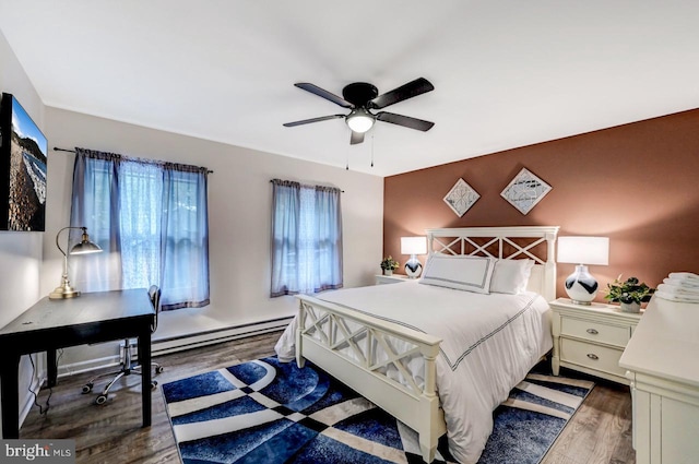 bedroom with baseboard heating, ceiling fan, and dark wood-type flooring