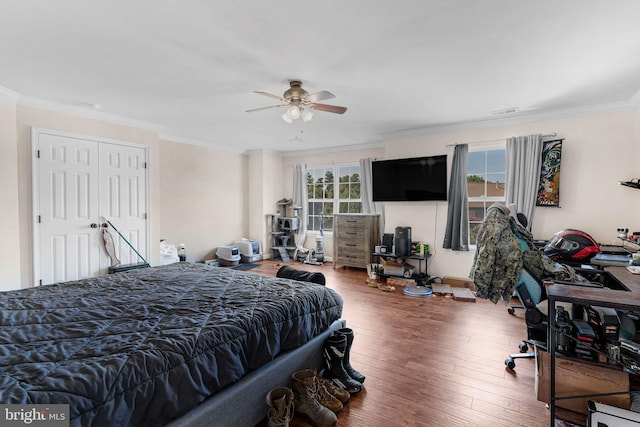 bedroom with ceiling fan, a closet, hardwood / wood-style flooring, and ornamental molding