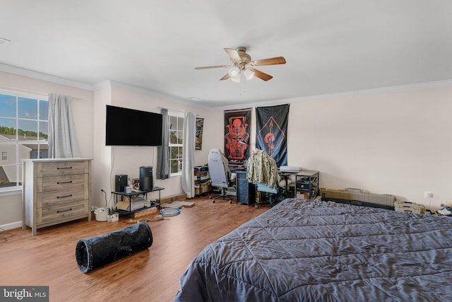 bedroom with ceiling fan, hardwood / wood-style floors, crown molding, and multiple windows