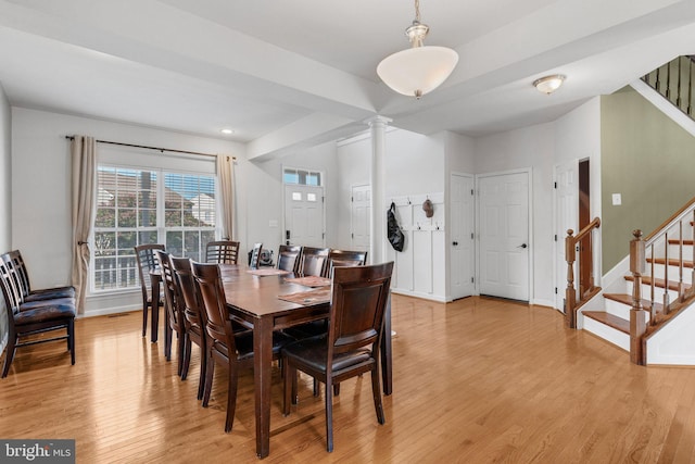 dining area with light wood-type flooring and ornate columns