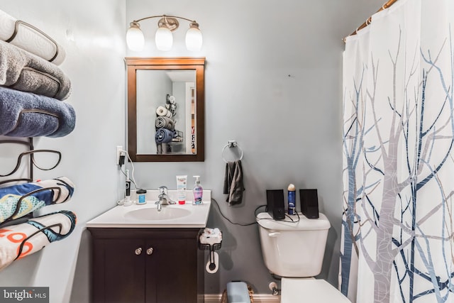 bathroom with toilet, vanity, and a shower with curtain