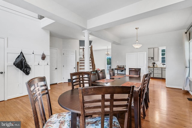 dining room with a wealth of natural light, light hardwood / wood-style flooring, and ornate columns