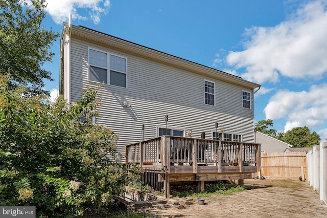 rear view of house featuring a wooden deck