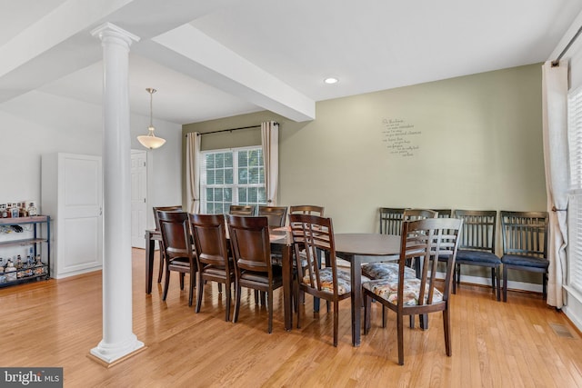 dining space with beamed ceiling, light hardwood / wood-style flooring, and decorative columns