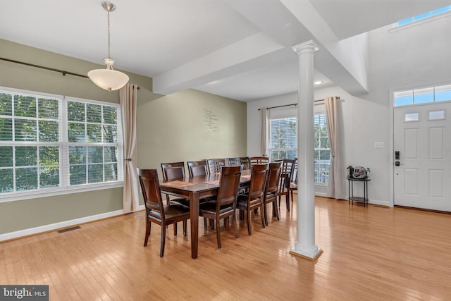 dining space featuring light hardwood / wood-style flooring and decorative columns