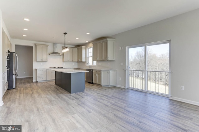 kitchen featuring gray cabinets, a kitchen island, pendant lighting, and wall chimney range hood