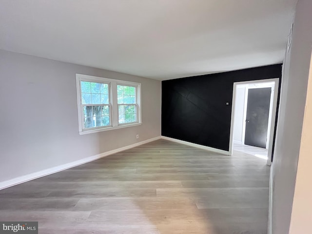 spare room with light wood finished floors and baseboards