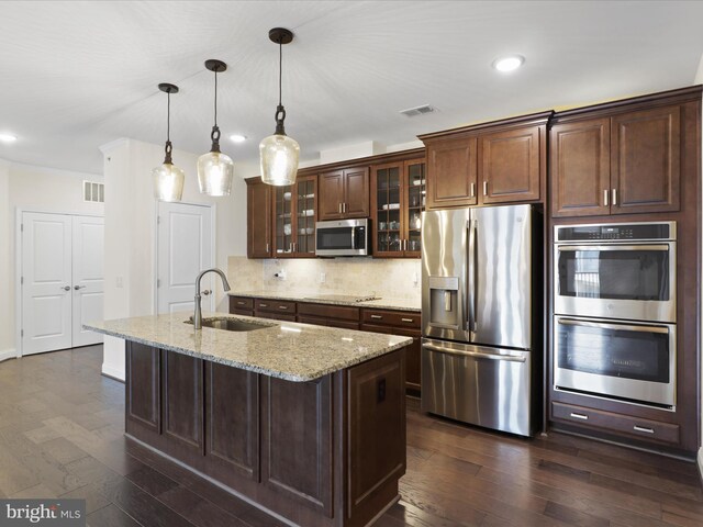 kitchen with stainless steel appliances, tasteful backsplash, sink, light stone counters, and dark hardwood / wood-style flooring