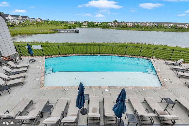 view of pool with a patio area and a water view