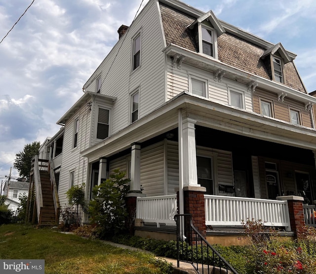 view of side of property featuring covered porch