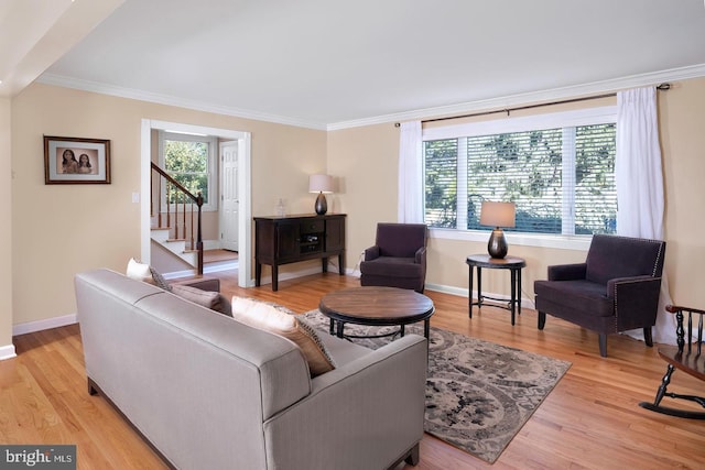 living area with light wood-type flooring, baseboards, and crown molding