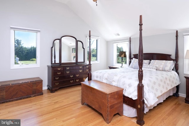 bedroom featuring vaulted ceiling, visible vents, light wood-style flooring, and baseboards