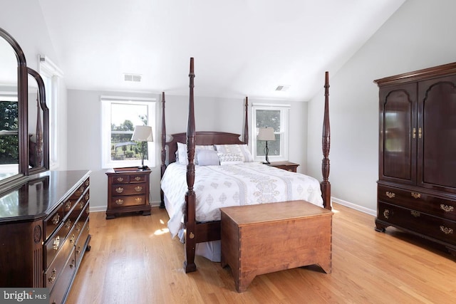 bedroom with lofted ceiling, baseboards, visible vents, and light wood-style floors