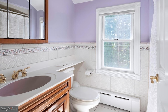 full bath with toilet, tile patterned flooring, baseboard heating, vanity, and tile walls