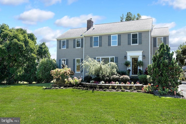 view of front of home featuring a chimney and a front yard