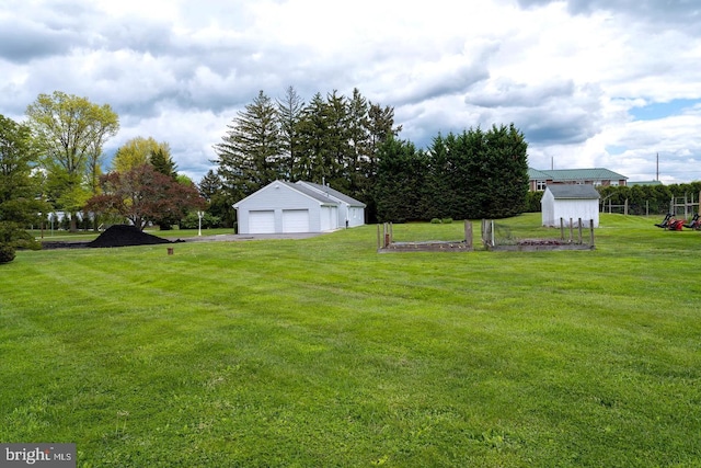 view of yard with a garage and an outbuilding